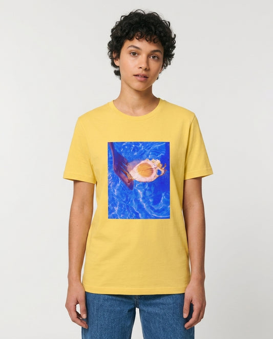 Person wearing a yellow t-shirt with a graphic design on a plain background