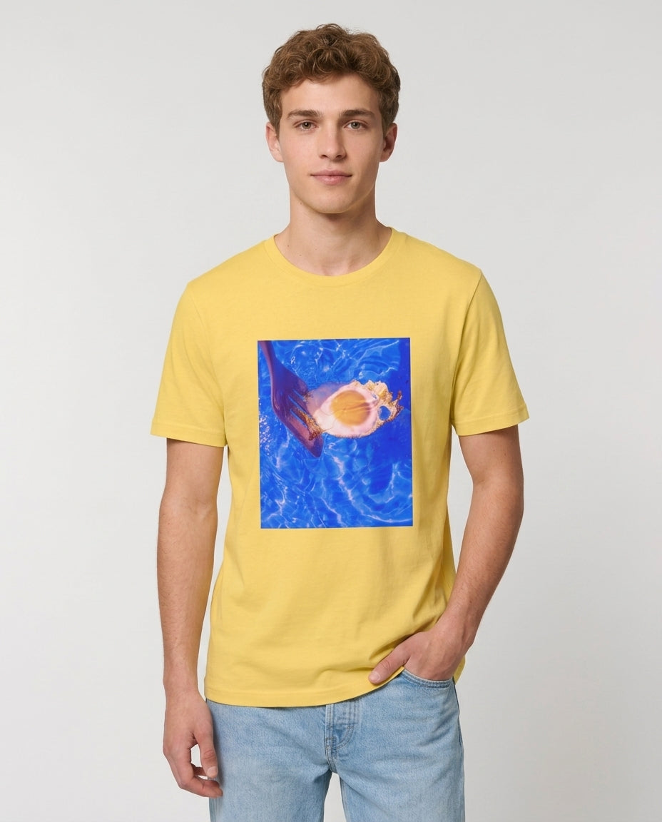 Man wearing a yellow t-shirt with a graphic design on a plain background