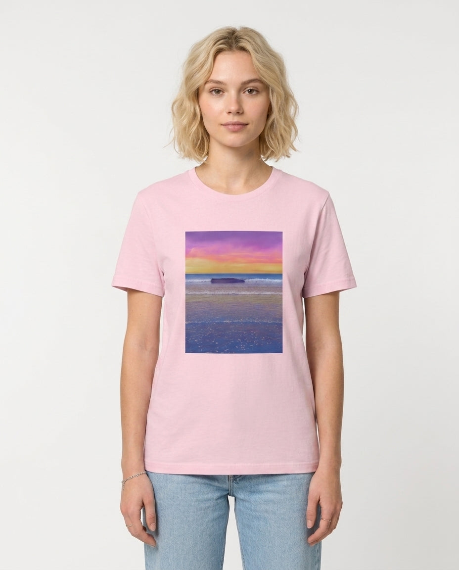 Female model wearing Pink t-shirt with a colorful beach scene print on a white background