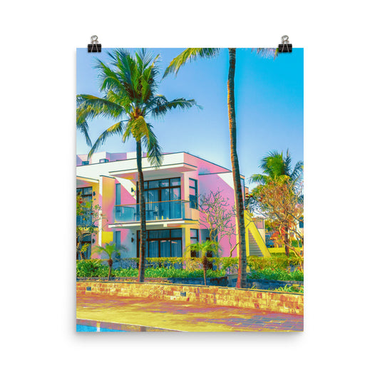 Unframed fine art print of a pink and yellow modernist resort building framed by tall palm trees, vivid tropical colours against a clear blue sky, styled for living room or home office wall art