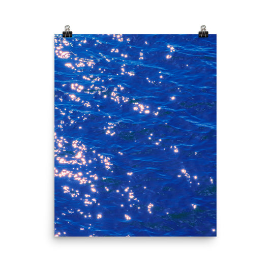Unframed poster print of deep cobalt blue ocean water covered in scattered golden starburst sunlight reflections, displayed as fine art wall decor.​​​​​​​​​​​​​​​​