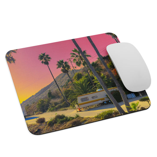 Mouse pad with a scenic design of palm trees and an RV, featuring a mouse on top.