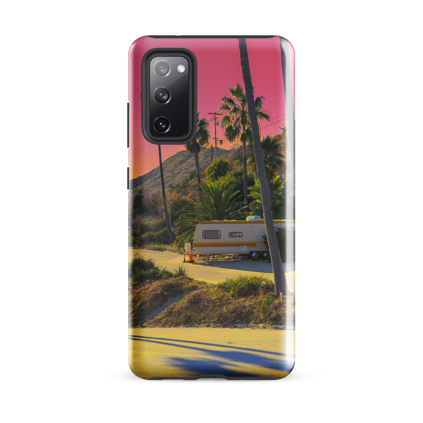 Phone case with a scenic design of a road, trailer, and palm trees at sunset.